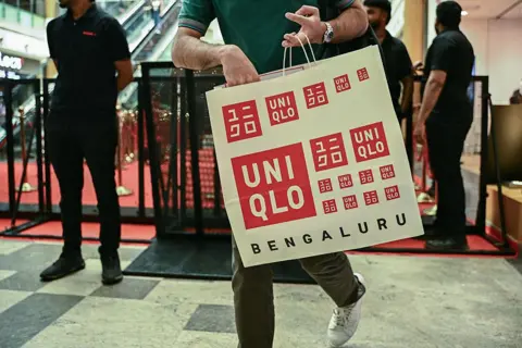 Getty Images A man walks out after shopping at the newly launched Japanese retail store UNIQLO at Orion Mall in Bengaluru, August 29, 2025.