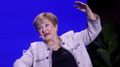 Getty Images Kristalina Georgieva, managing director of the IMF, speaking during the Qatar Economic Forum in New York, US, this month. She sitting down in a chair explaining her answer to a question as she raises her left arm above her head.