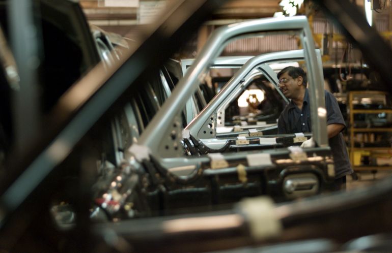 An engineer works on cars at a Tata Motors plant near Pune, India
