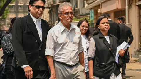 Getty Images Satish Salian, Disha's father, flanked by lawyers.