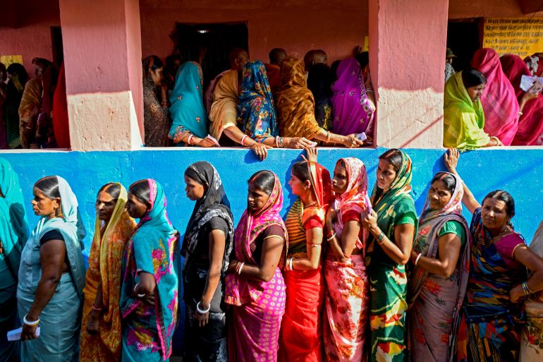 Women voters stand in queues to cast their ballots at a polling station during the first phase of voting for assembly elections on November 6, 2025, at the Raghopur constituency in the Vaishali district of the Indian state of Bihar