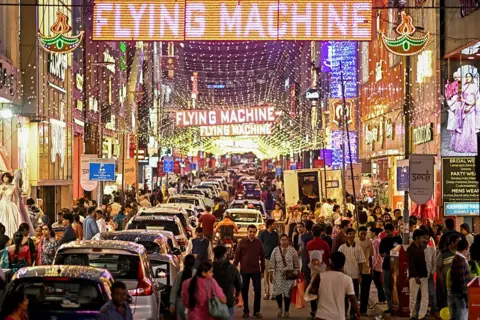 AFP via Getty Images Shoppers gather at the illuminated Commercial Street on the eve of Diwali, the Hindu festival of lights, in Bengaluru on 19 October 2025.