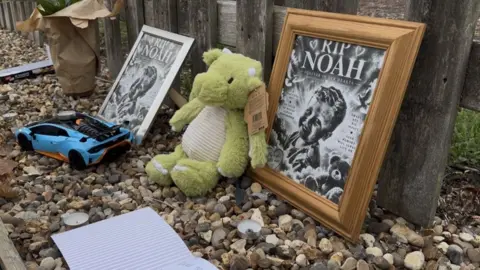 Zoie O'Brien/BBC Teddy bear, car and two framed pictures next to a fence