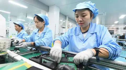 VCG via Getty Images Workers produce export orders at the workshop of Dongfang Jiule Automotive Electronics (Shanghai) Co., Ltd. Xinle Branch on September 15, 2026 in Xinle, Hebei Province of China.