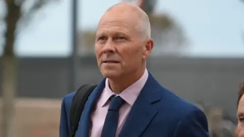 BBC A bald man in a blue suit