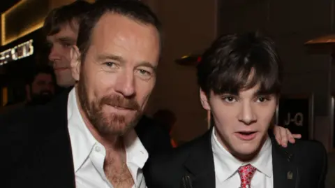 Getty Images Bryan Cranston and RJ Mitte in white shirts and dark suits in 2008 at the premiere of Breaking Bad