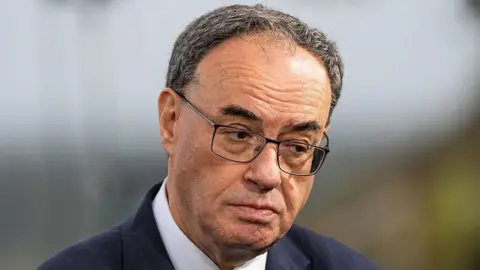 Bloomberg via Getty Images A close up of Bank of England Governor Andrew Bailey looking to one side wearing a navy suit and white shirt