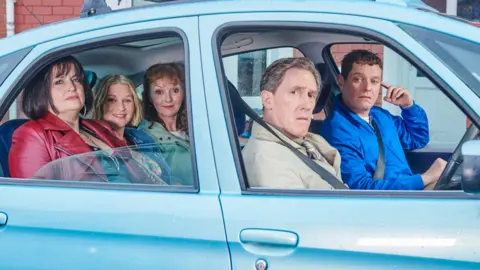 BBC/Toffee International Ltd/Tom Jackson The cast of Gavin & Stacey sitting in a blue car in the 2024 Christmas special