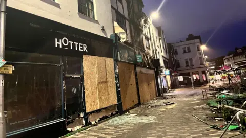 Fire-damaged shops, boarded up