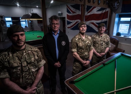 Falkland Islands reservists and an emergency services director stand around a pool table