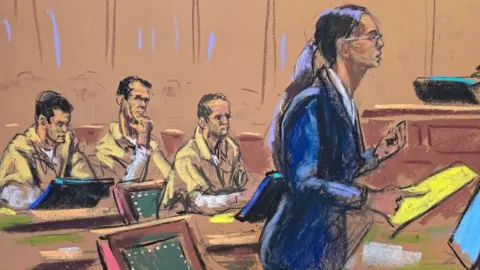 Reuters A court sketch of a woman in a blue suit with glasses and long brown hair tied back in a ponytail addressing a courtroom while three men in khaki prison jumpsuits sit watching.
