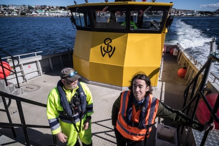 James Wallace and bosun Trevor Law stand on his harbour launch near Port Stanley