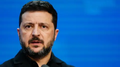 Getty Images Close up of Zelensky's face at the news conference, with a bright blue background.