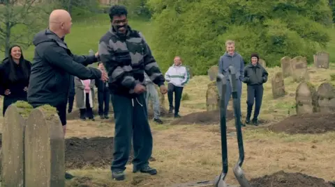 Ross Kemp and Romesh Ranganathan in the Celebrity Traitors, standing outside with the graves as part of the latest mission